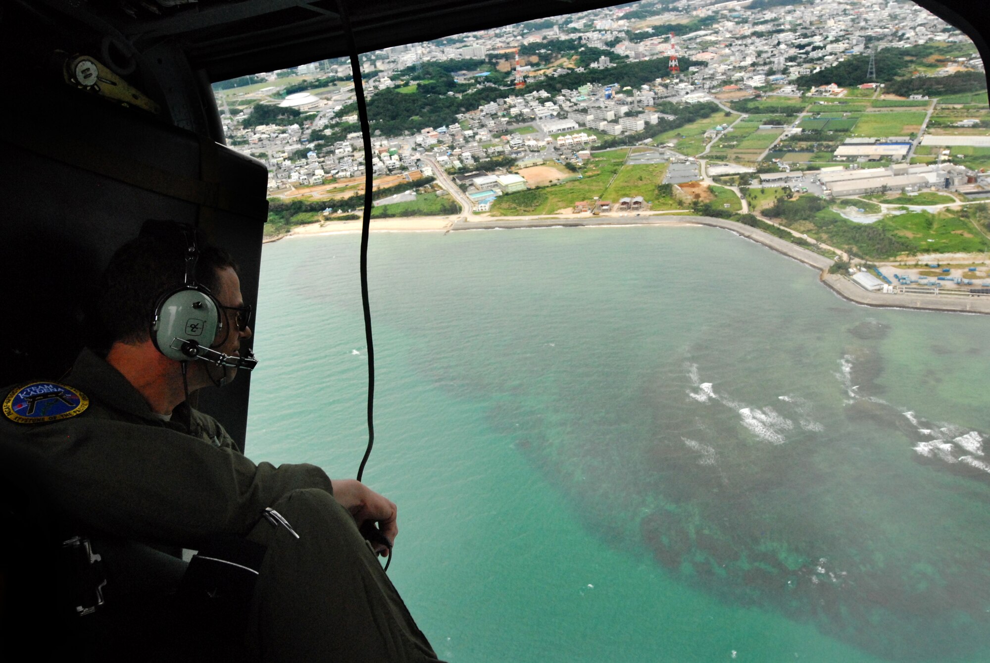 U.S. Air Force Brig. Gen. Matthew Molloy, 18th Wing commander, surveys the area from a U.S. Air Force HH-60 Pave Hawk during the Cope Angel exercise in Okinawa, Japan, Dec. 5, 2011. One of the goals of this exercise is to demonstrate safe and effective bilateral planning and execution. (U.S. Air Force photo by Tech. Sgt. Lakisha A. Croley/Released) 