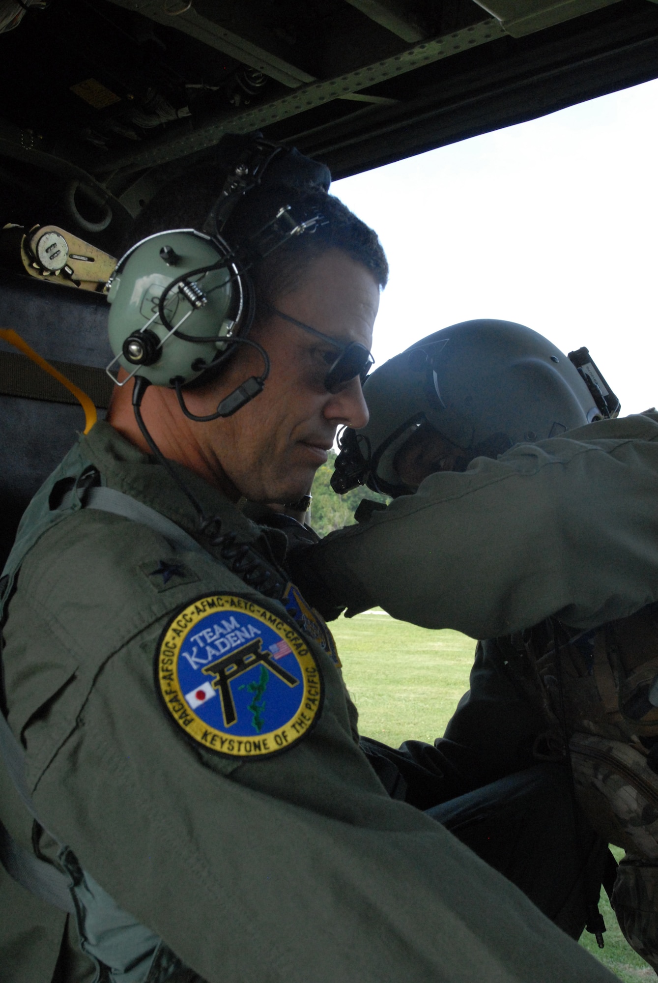 U.S. Air Force Brig. Gen. Matthew Molloy, 18th Wing commander, gets assistance strapping into a U.S. Air Force HH-60 Pave Hawk by U.S. Air Force Staff Sgt. Will Gonzalez, 33rd Rescue Squadron gunner, before takeoff on Kadena Air Base, Japan, Dec. 5, 2011, during the Cope Angel exercise. One of the goals of this exercise is to demonstrate safe and effective bilateral planning and execution. (U.S. Air Force photo by Tech. Sgt. Lakisha A. Croley/Released) 
