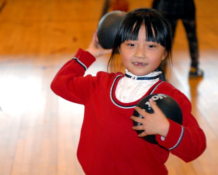 An Ilmagwon Orphanage girl winds up as she prepares to throw a dodge ball during the girl’s visit for a Christmas party at Kunsan Air Base, Republic of Korea, Dec. 3, 2011. With open arms, 63 Wolf Pack members graciously welcomed the orphans to their home for an afternoon of fun, games, food and presents. (U.S. Air Force photo by Senior Airman Benjamin Stratton/Released)