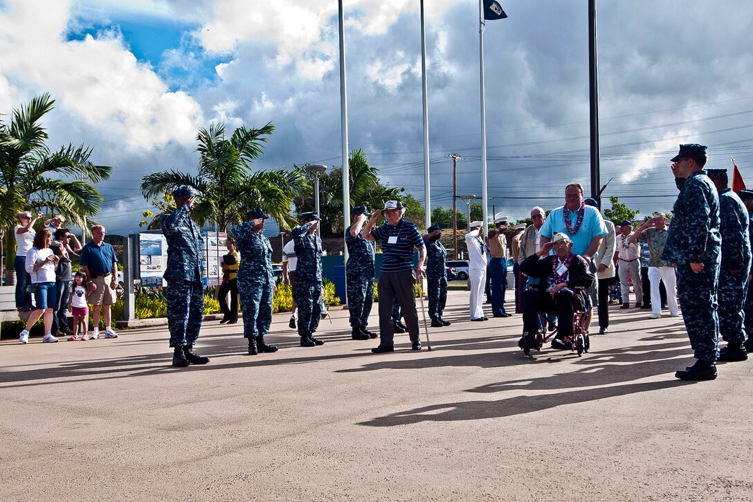 Navy veterans, who were aboard the battleship USS Arizona during the Dec. 7, 1941, Japanese air attack on Pearl Harbor, are greeted with honors as they enter the World War II Valor in the Pacific National Monument in Pearl Harbor, Hawaii, Dec. 6, 2011. The monument is hosting ceremonies throughout the week in remembrance of the attack on Pearl Harbor. 