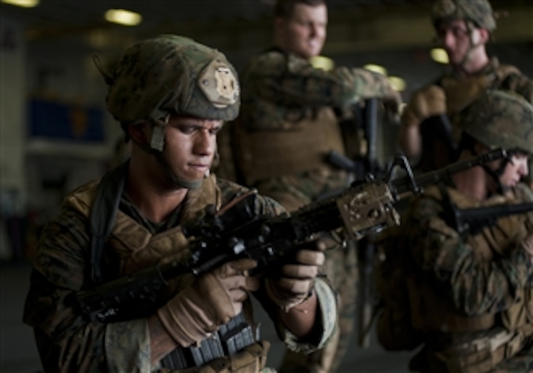U.S. Marine Corps Sgt. Alex Sanchez, assigned to the 11th Marine Expeditionary Unit, uses an M4 carbine to practice weapon malfunction drills in the hangar bay of the amphibious assault ship USS Makin Island (LHD 8) in the Pacific Ocean on Dec. 2, 2011.  The Makin Island and the 11th Marine Expeditionary Unit are deployed to the U.S. 5th Fleet and U.S. 7th Fleet areas of responsibility.  