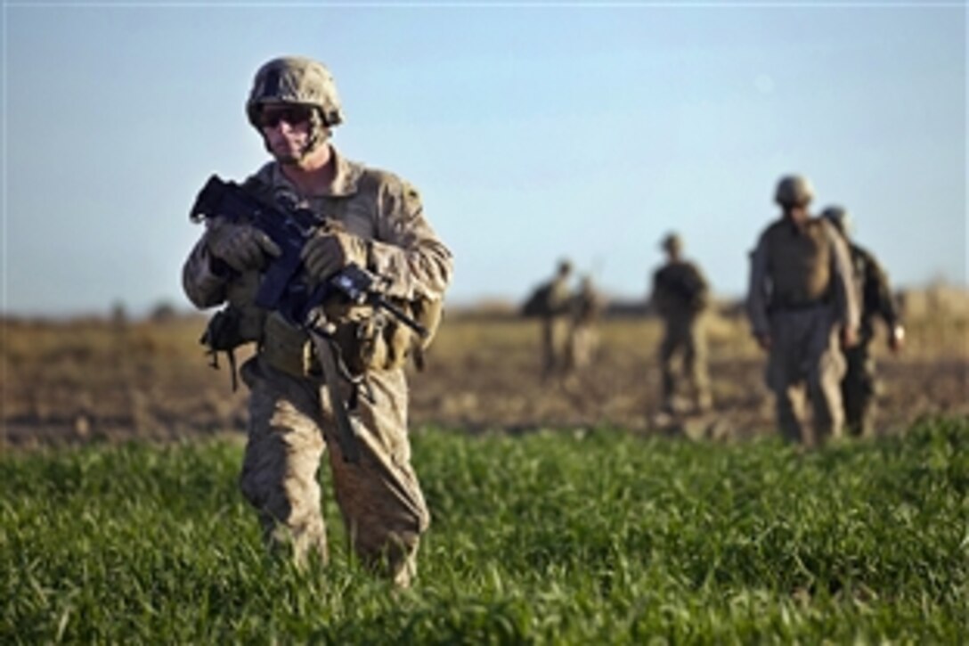 U.S. Marine Corps Staff Sgt. Christopher Ballance walks through a field during a security patrol in the Garmser District, Helmand province, Afghanistan, Dec. 2, 2011. Ballance is assigned to Weapons Company, 3rd Battalion, 3rd Marine Regiment.