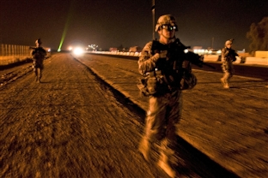 U.S. Army military policemen conduct a dismounted patrol along a road outside Camp Taji, Iraq, Dec. 2, 2011. The policemen are assigned to the 82nd Airborne Division's 2nd Brigade, Company H, 2nd Brigade Special Troops Battalion. 