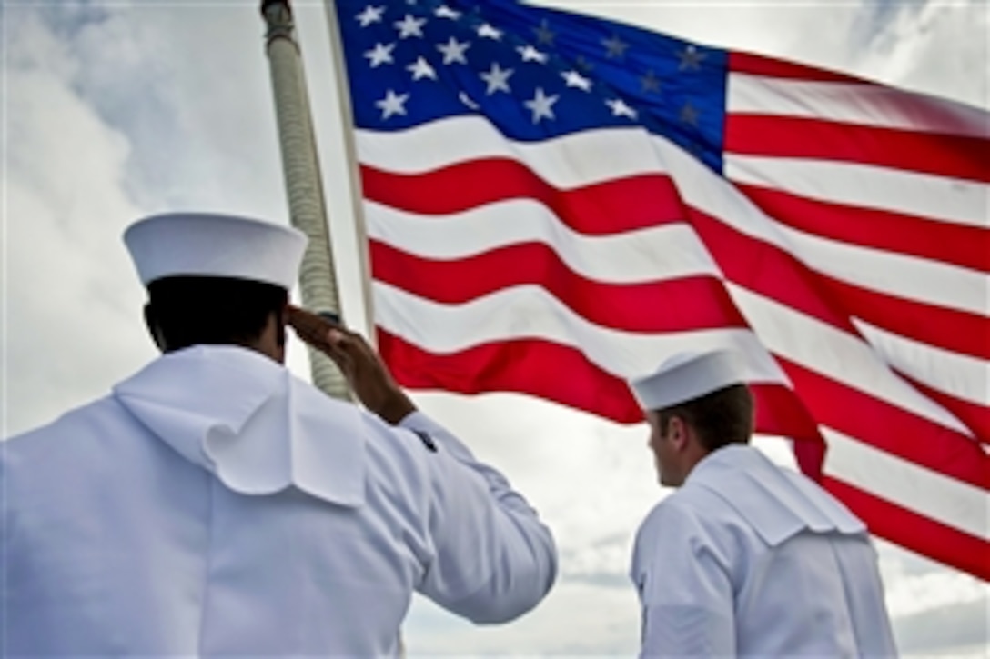 U.S. sailors, part of a flag detail, salute the national ensign aboard the amphibious dock landing ship USS Pearl Harbor in the Philippine Sea, Dec. 7, 2011, during a remembrance ceremony for the Dec. 7, 1941, attack. The Pearl Harbor and Marines assigned to the 11th Marine Expeditionary Unit are conducting operations in the U.S. 7th Fleet area of responsibility as part of the Makin Island Amphibious Ready Group.