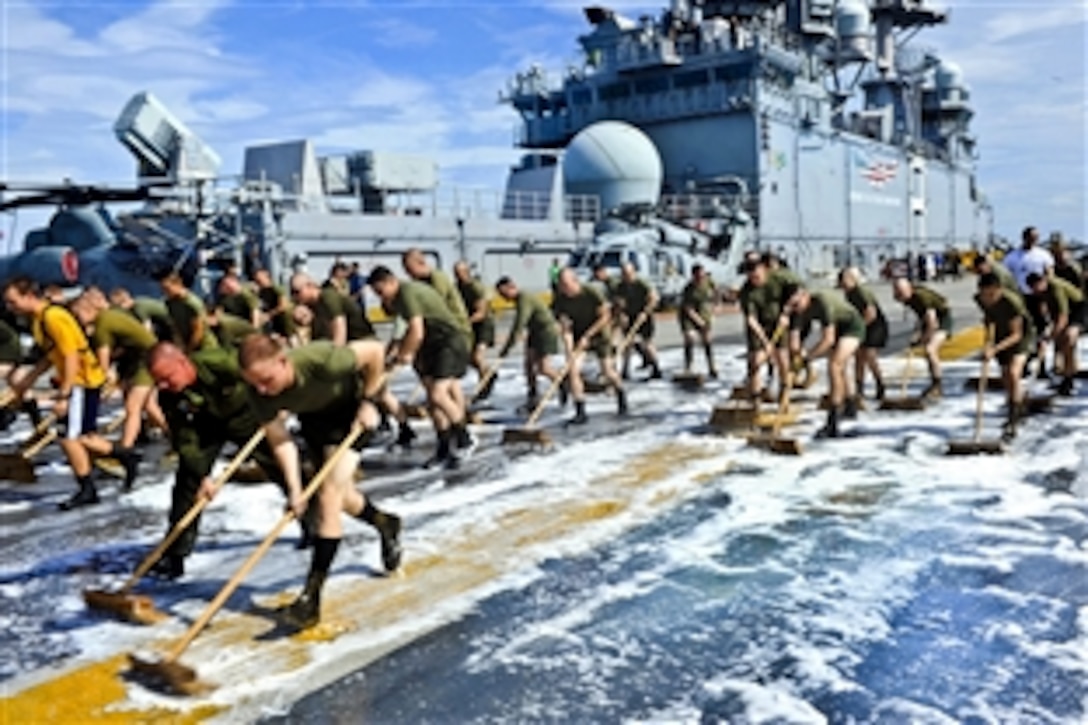 U.S. Navy sailors and Marines scrub down the flight deck of the amphibious assault ship USS Makin Island under way in the Pacific Ocean, Dec. 7, 2011. The Marines are assigned to the 11th Marine Expeditionary Unit. The Makin Island, the Navy's newest amphibious assault ship and the only U.S. Navy ship with a hybrid electric propulsion system, is on its first operational deployment.