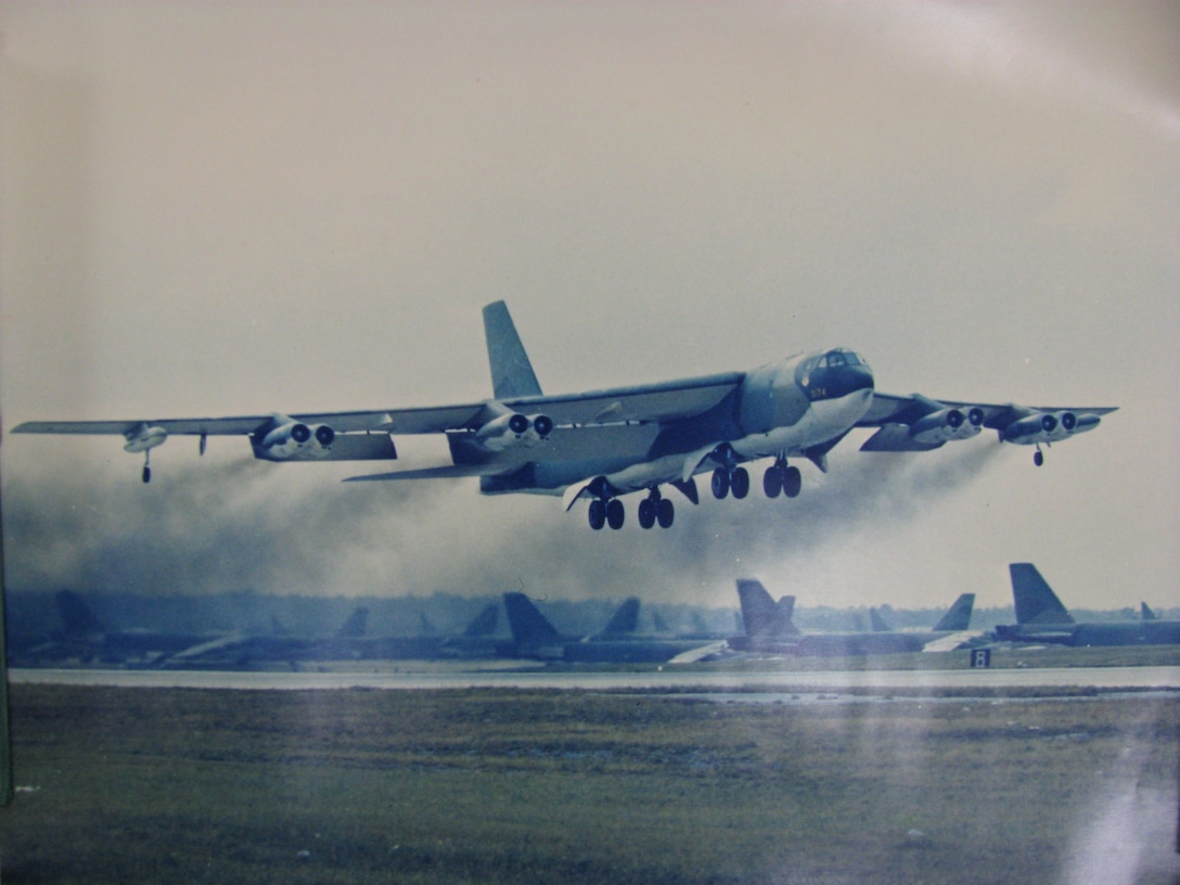 A B-52 Stratofortress bomber takes off from a runway.