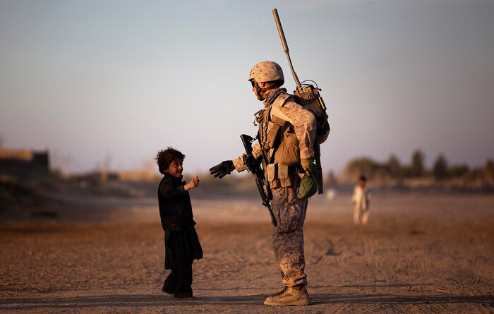 U.S. Marine Lance Cpl. Jon Lyman, a 21-year-old mortarman with Weapons Company, 3rd Battalion, 3rd Marine Regiment and native of Oregon City, Ore., hands a piece of candy to an Afghan child during a security patrol here, Nov. 30. Afghan National Army soldiers and 3/3 Marines met with local elders at a shura and built rapport with local children during the patrol. The Marines of ‚America‚s Battalion‚ will continue mentoring the Afghan National Security Forces as they assume security responsibility in Garmsir district. Their interoperability is designed to further the expansion of stability, development and legitimate governance of Afghanistan by defeating insurgent forces and helping secure the Afghan people.