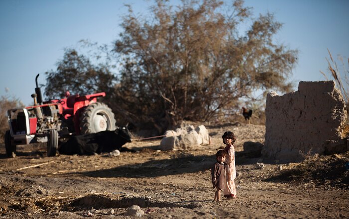 Afghan children watch Afghan National Army soldiers and U.S. Marines from Weapons Company, 3rd Battalion, 3rd Marine Regiment walk through their village during a security patrol here, Dec. 2. The ANA soldiers and 3/3 Marines met with local elders at a shura and built rapport with local children during the patrol. The Marines of ‚America‚s Battalion‚ will continue mentoring Afghan National Security Forces as they assume security responsibility in Garmsir district. Their interoperability is designed to further the expansion of stability, development and legitimate governance of Afghanistan by defeating insurgent forces and helping secure the Afghan people.