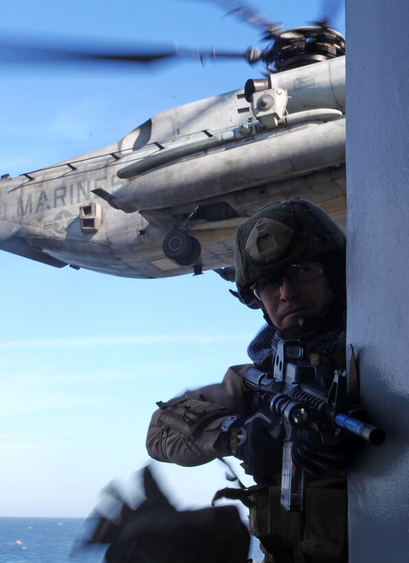 A student maintains a visual of the rooftop as he climbs a ladder to locate and close with the enemy.