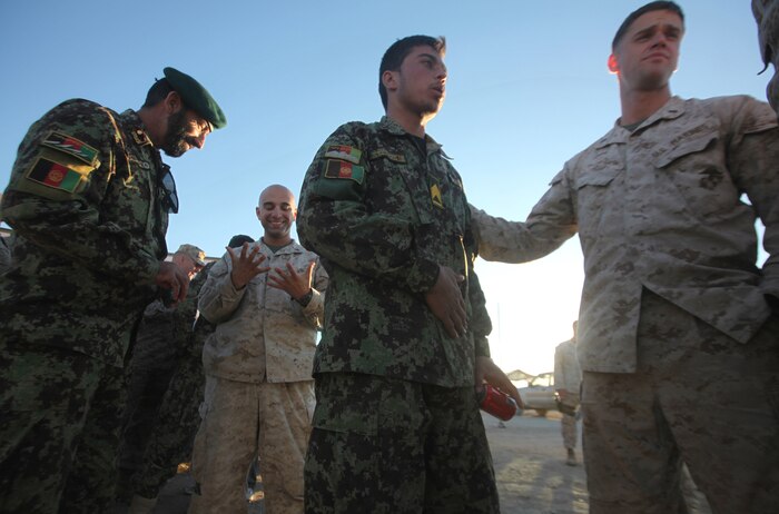 Marines with the Embedded Partnering Team, 2nd Marine Logistics Group (Forward), greet their Afghan National Army counterparts during a farewell dinner aboard Camp Leatherneck, Afghanistan, Dec. 9.  The ANA is transferring to more independent operations in the coming weeks.  (U.S. Marine Corps photo by Cpl. Katherine M. Solano)