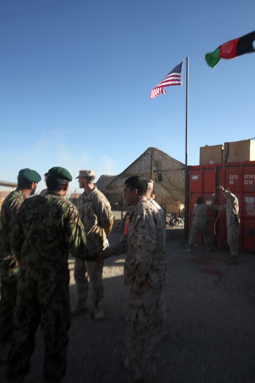 Marines with the Embedded Partnering Team, 2nd Marine Logistics Group (Forward), greet their Afghan National Army counterparts during a farewell dinner aboard Camp Leatherneck, Afghanistan, Dec. 9.  The ANA is transferring to more independent operations in the coming weeks.  (U.S. Marine Corps photo by Cpl. Katherine M. Solano)