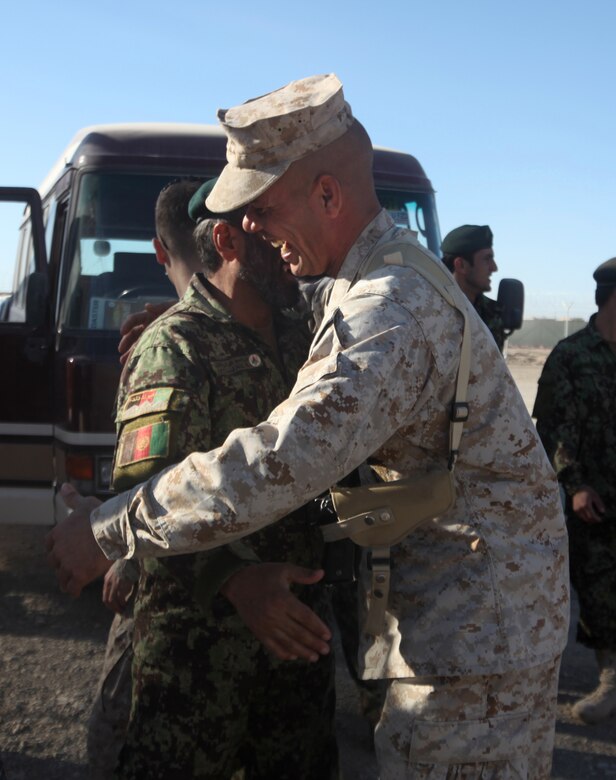 Gunnery Sgt. John Alicia, the transportation chief with the Embedded Partnering Team, 2nd Marine Logistics Group (Forward), greets Afghan National Army soldiers at the EPT lot aboard Camp Leatherneck, Afghanistan, Dec. 9.  The ANA and EPT came together for a farewell meal as they transitition to different training.  (U.S. Marine Corps photo by Cpl. Katherine M. Solano)