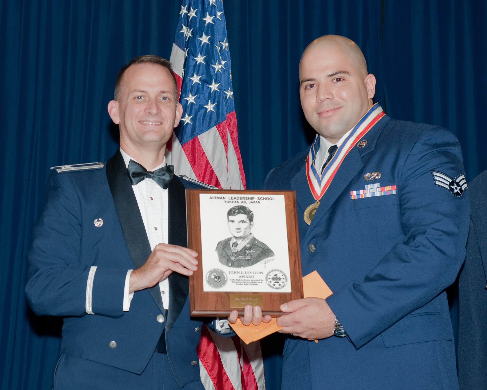 YOKOTA AIR BASE, Japan -- Senior Airman Daniel Ramos (right), 730th Air Mobility Squadron, receives the John L. Levitow Award from Col. William Knight (left), 374th Airlift Wing vice commander, during the Airman Leadership School Class 12-A graduation ceremony at Yokota Air Base, Japan, Dec. 8, 2011.  (U.S. Air Force photo/Osakabe Yasuo)
