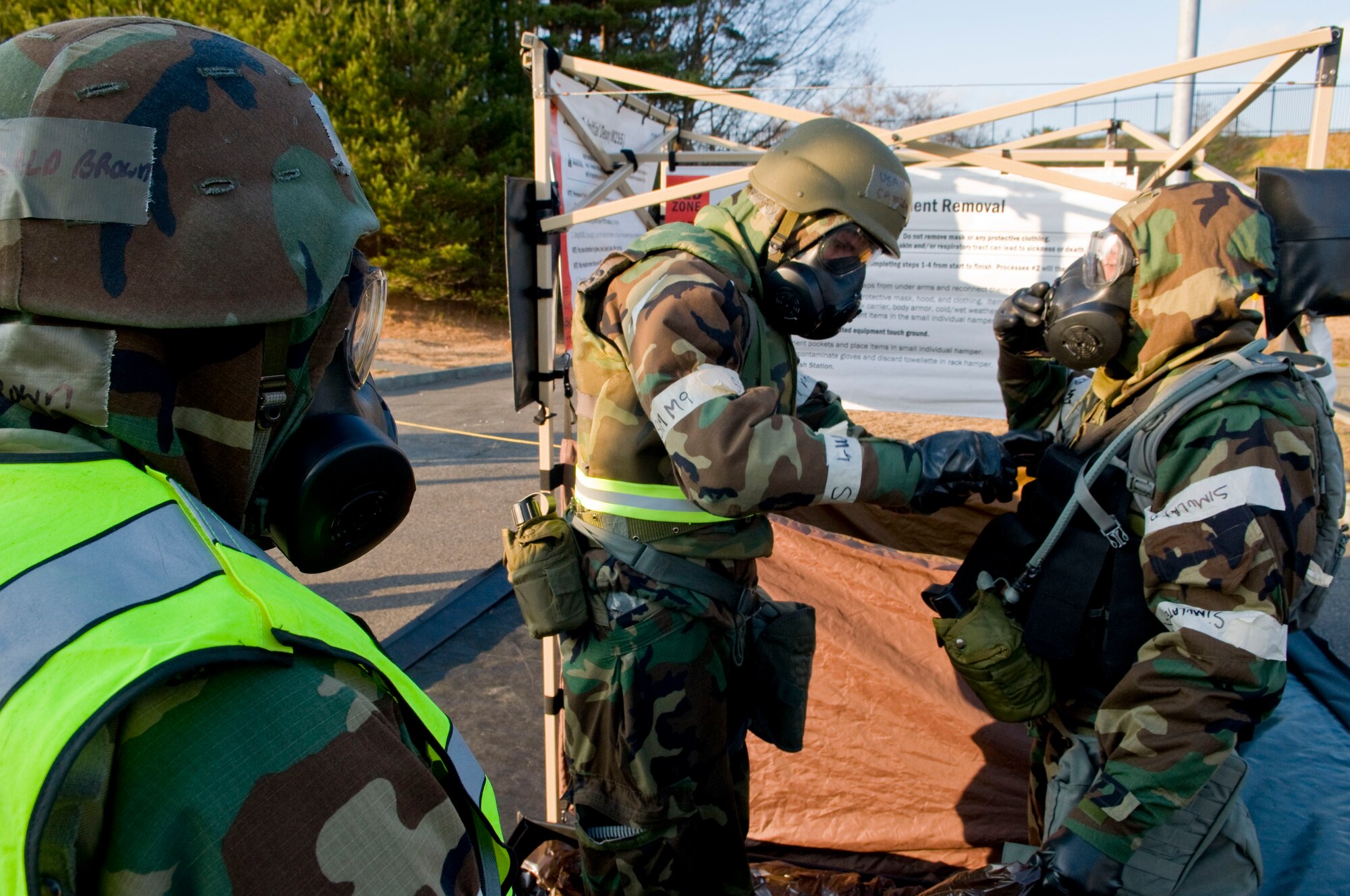 MISAWA AIR BASE, Japan - (left to right) Staff Sgt. Darald Brown, 35th Surgical Operations Squadron, observes Senior Airman Cameron Dungey, 35th Dental Squadron, and Senior Airman David Adola, 452nd Air Mobility Wing, March Air Reserve Base, Calif., decontaminating each other during an operational readiness inspection here Dec. 8. Pacific Air Forces Inspector General is inspecting the wing to test their ability to deploy and survive and operate in the deployed environment. (U.S. Air Force photo/Senior Airman Jess Lockoski) 