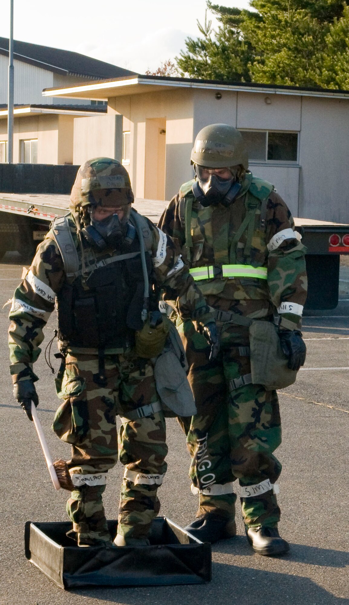MISAWA AIR BASE, Japan - Senior Airman David Adola, left, 452nd Air Mobility Wing, March Air Reserve Base, Calif., and Senior Airman Cameron Dungey, 35th Dental Squadron, process through a contamination control area during an operational readiness inspection here Dec. 8. Airmen exposed to the hazards of biological or chemical agents decontaminate themselves by processing through a CCA. Pacific Air Forces Inspector General is inspecting the wing to test their abilities to deploy and to survive and operate in the deployed environment. (U.S. Air Force photo/Senior Airman Jess Lockoski)
