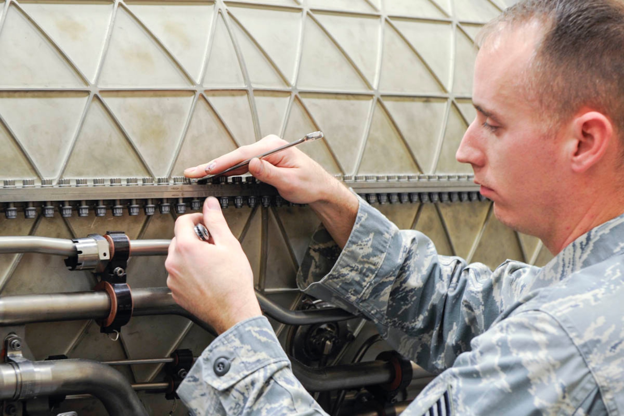 Tech. Sgt. Daniel Powers, 3rd Maintenance Squadron, Joint Base Elmendorf-Richardson. Removes one of almost 200 nuts and bolts needed to be removed before lifting the upper fan duct on a Raptor F119-100 engine.