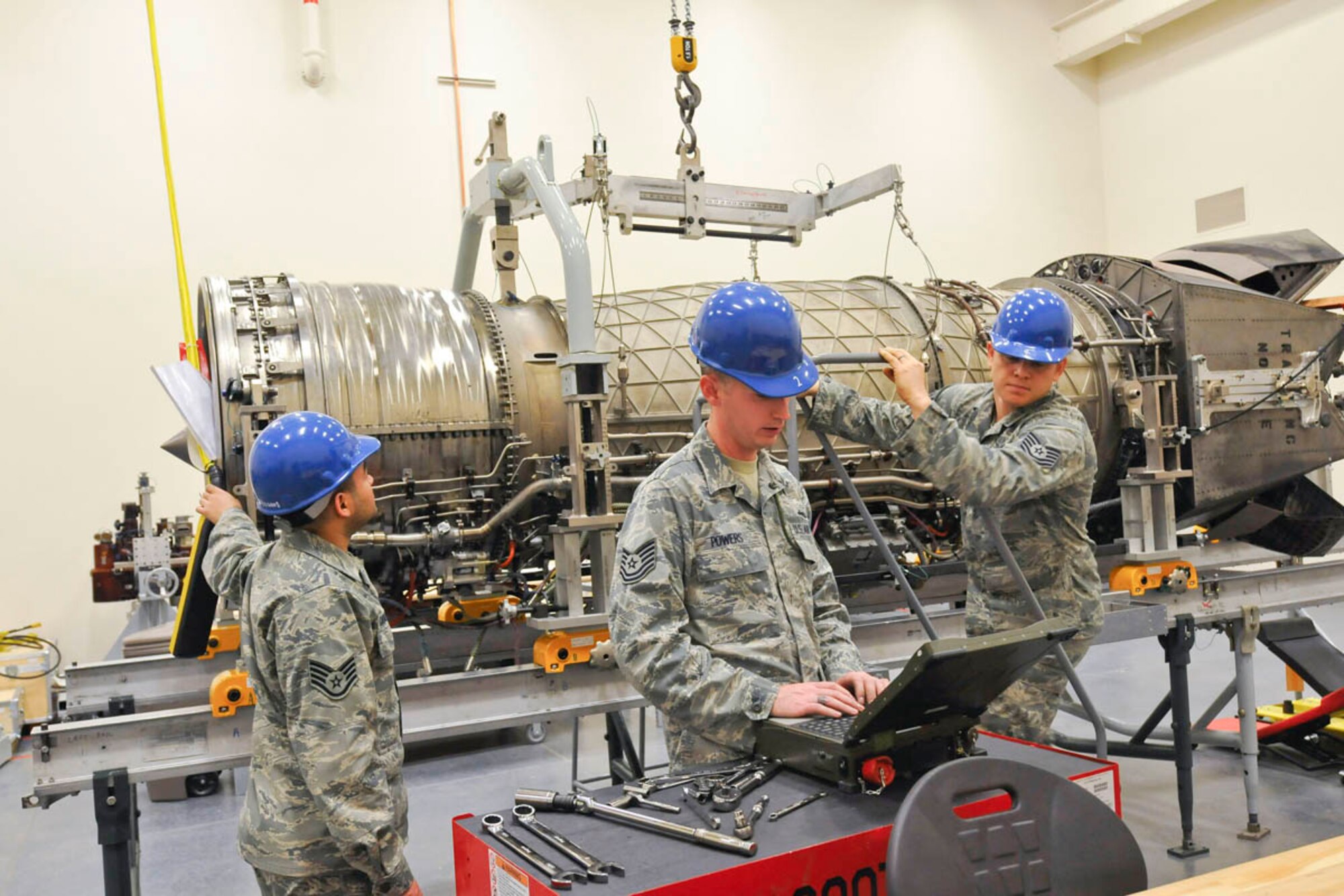 Air Force Staff Sgt. Jose Caballero crontols hoist while Tech. Sgt. Daniel Powers checks connections prior to removal of cover. Tech. Sgt. Dan Oden, instructor for the 372nd Training Squadron, Detachment 14. Caballero and Powers are assigned to 3rd Maintenance Squadron, Joint Base Elemendorf-Richardson.