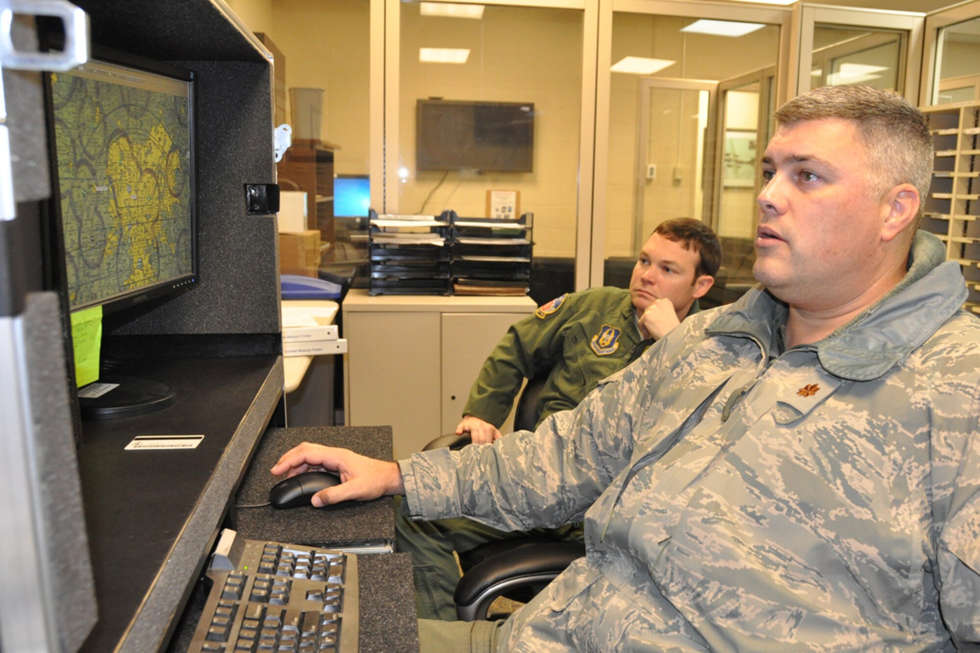 Maj. Robert Light, assistant director of operations, and 1st Lt. Patrick Croasdale, C-130 pilot, 700th Airlift Squadron plot drop zones and prepare to participate in the 14th Annual Randy Oler Memorial Operation Toy Drop, taking place just outside of Fort Bragg, N.C. Dec 10. Croasdale uses physical maps while Light uses Combat Flight Planning Software (CGPS) to decide which “roads” in the sky to use. This is the second year that Dobbins ARB is participating in the toy drop. Approximately 1600 paratroopers from the U.S. Army Civil Affairs and Psychological Operations Command, 18th Airborne Corps and visiting paratroopers from across the nation will parachute from Dobbins’ C-130 aircraft and deliver new, unwrapped toys to be distributed to local children's homes and social service agencies. (U.S. Air Force photo/Senior Airman Christina Bozeman)