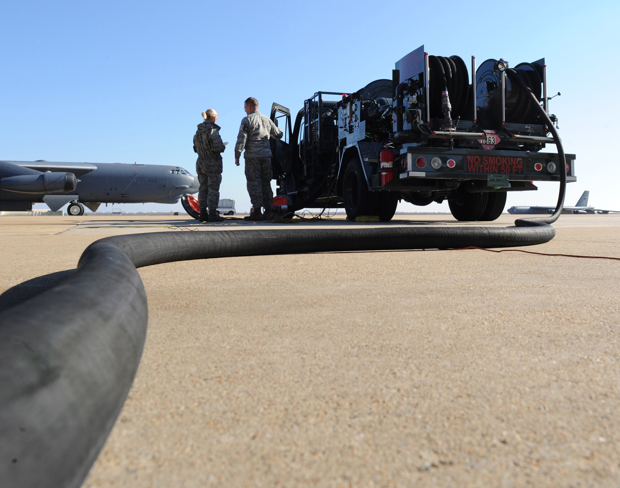 Senior Airman Benjamin McCann and Airman 1st Class Rachel Rodgers, 2nd Logistics Readiness Squadron fuel distribution operators, look at a technical order while refueling a B-52H Stratofortress on Barksdale Air Force Base, La., Dec. 7. R-12 fuel trucks are used to refuel B-52s which are capable of holding more than 310,000 pounds of fuel. (U.S. Air Force photo/Airman 1st Class Micaiah Anthony)(RELEASED)