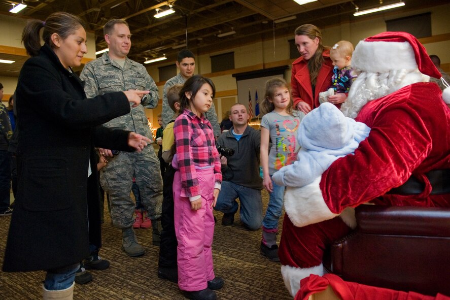 Children of all ages wait their turn to sit on Santa's lap as parents stand by to take photos. Santa visited the Grizzly Bend Dec. 1 during the tree lighting ceremony. (U.S. Air Force photo/Beau Wade)