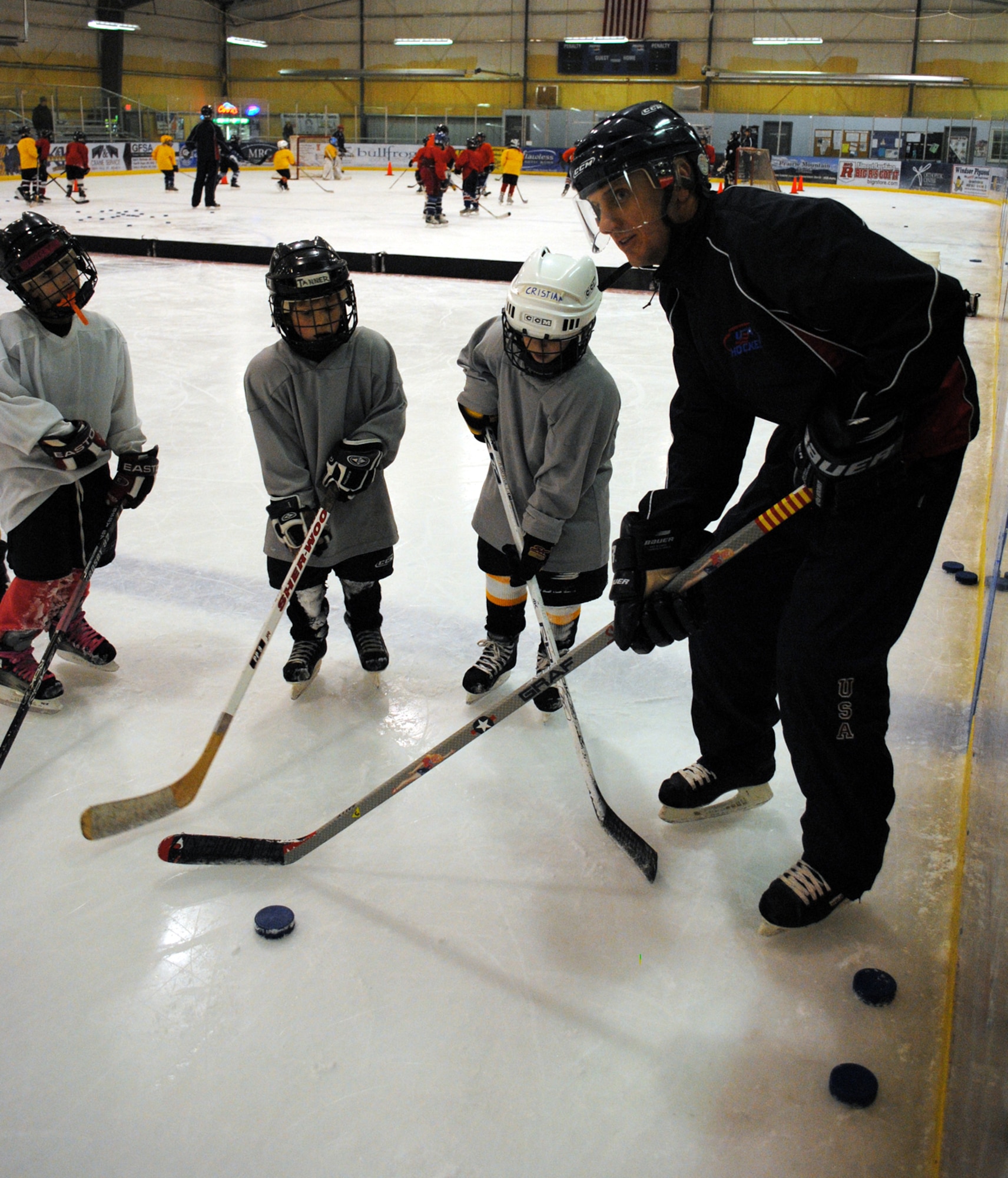Lt. Col. Matthew Guenther, 490th Missile Squadron commander, also a coach for the Squirts of Great Falls, which is a hockey team for first-timers from the ages ot 6 to 10, pumps up the little Squirts as they get ready to skate after a puck and try to make a shot during hockey practice Dec. 6. (U.S. Air Force photo/Airman 1st Class Katrina Heikkinen)