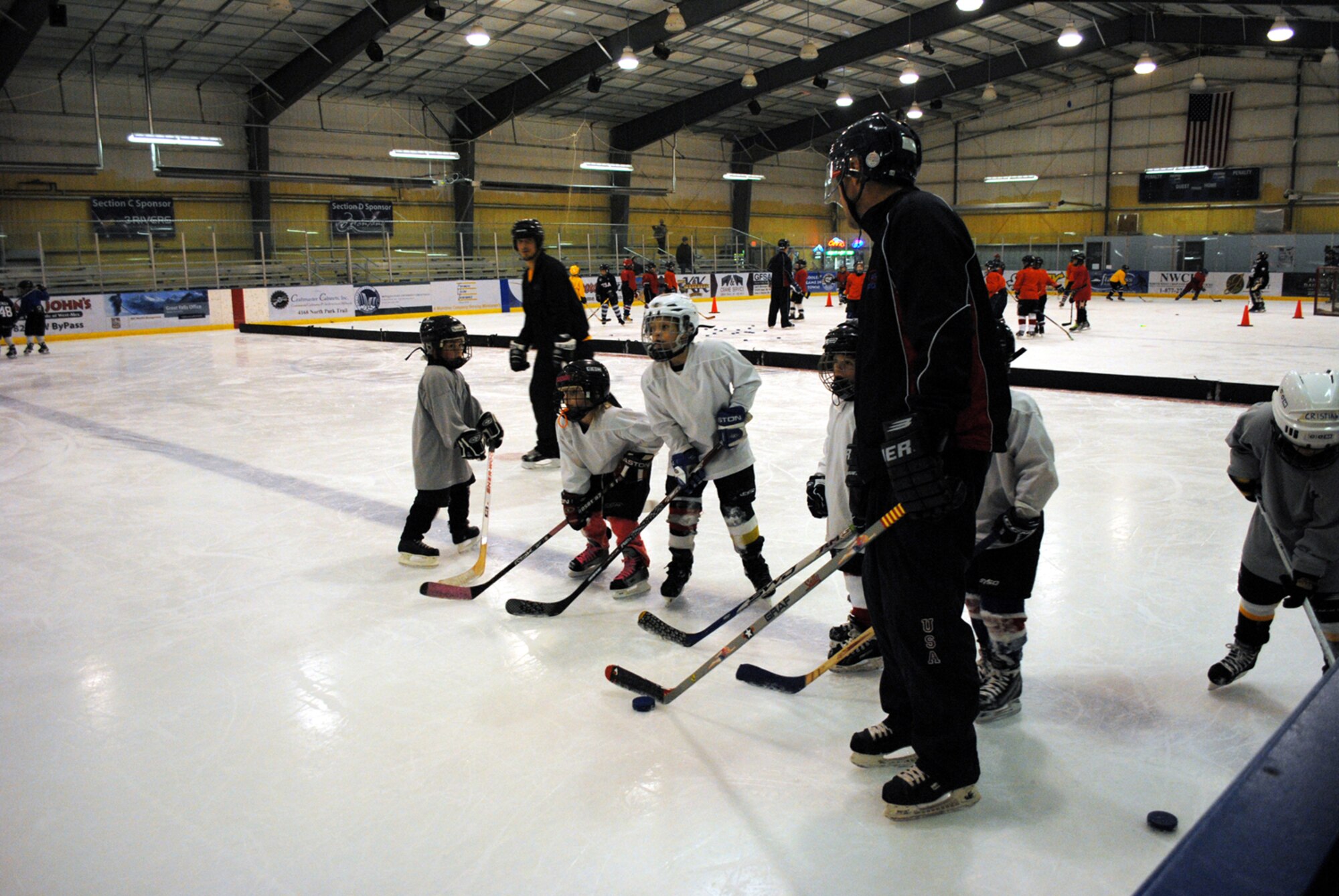 Lt. Col. Matthew Guenther, 490th Missile Squadron commander, also a coach for the Squirts of Great Falls, which is a hockey team for first-timers from the ages ot 6 to 10, pumps up the little Squirts as they get ready to skate after a puck and try to make a shot during hockey practice Dec. 6. (U.S. Air Force photo/Airman 1st Class Katrina Heikkinen)