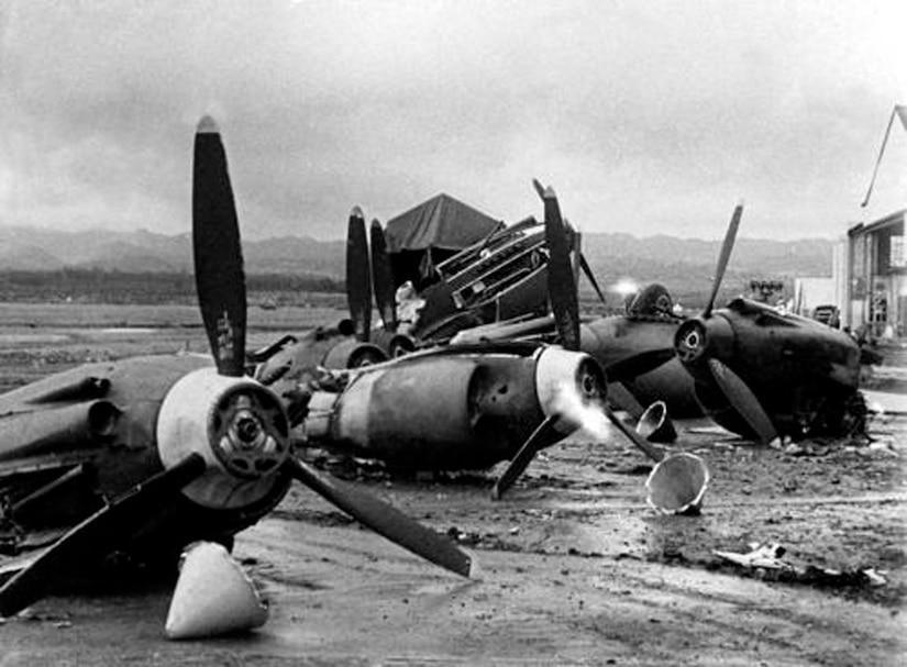 The wreckage of US Army Air Corps Aircraft at Hickam Field.  Of the 50 aircraft assigned to the 11th Bomb Group, 37 were damaged or destroyed in the attack.  Several of the suriving 11 BG aircraft participated in the search for the Japanese carrier force hours after the attack. (Courtesy Photo/Air Force Historical Research Agency)