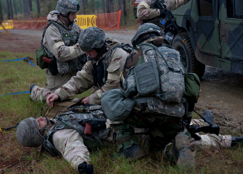 Airmen participating in a phase II operational readiness exercise conduct self-aid and buddy care on an injured Airman after a simulated terrorist attack by a suicide bomber at a field training exercise site at Moody Air Force Base, Ga., Dec. 7, 2011. Inspectors during an operational readiness inspection scheduled for next spring will observe Moody Airmen’s ability to tend to wounds while waiting for emergency medical teams to arrive. (U.S. Air Force photo by Senior Airman Eileen Meier/Released)