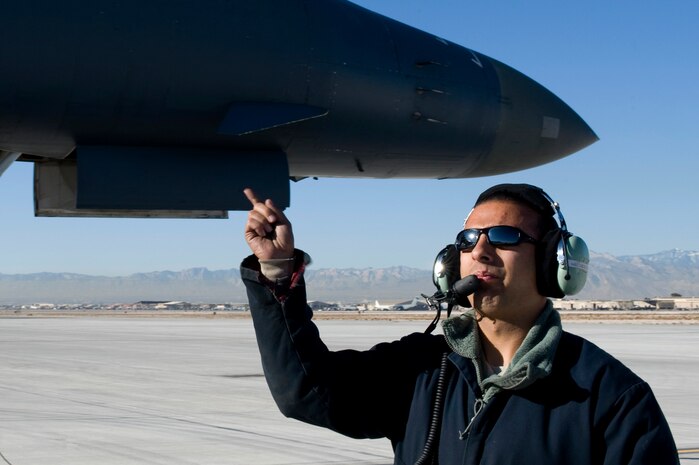 U.S. Air Force Staff Sgt. Trevor Helm, 7th Aircraft Maintenance Squadron crew chief, Dyess Air Force Base, Texas, prepares to marshal a B-1 Lancer, 77th Weapons Squadron, Dyess Air Force Base, Texas, during the U.S. Air Force Weapons School mission employment phase Dec. 7, 2011, at Nellis Air Force Base, Nev. The mission employment phase is the final part of a two week Weapons School graduate course that showcases the newly acquired skills from the school's students. (U.S. Air Force photo by Airman 1st Class Matthew Lancaster/Released)