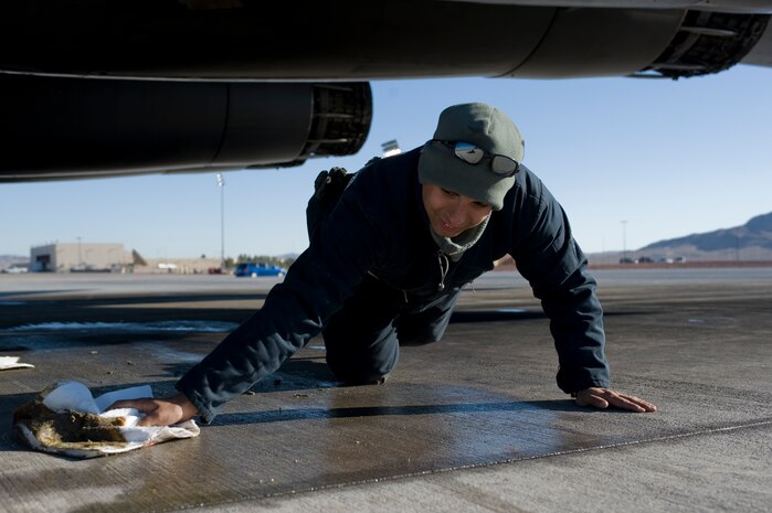 U.S. Air Force Staff Sgt. Trevor Helm, 7th Aircraft Maintenance Squadron crew chief, Dyess Air Force Base, Texas,cleans around a B-1 Lancer, 77th Weapons Squadron, Dyess Air Force Base, Texas, during the U.S. Air Force Weapons School mission employment exercise Dec. 7, 2011, at Nellis Air Force Base, Nev. The two-week-long mission employment phase is the final part of a five-and-a-half-month Weapons School graduate course that showcases the students newly acquired skills to test their ability to plan, execute and lead complex missions. (U.S. Air Force photo by Airman 1st Class Matthew Lancaster/Released)
