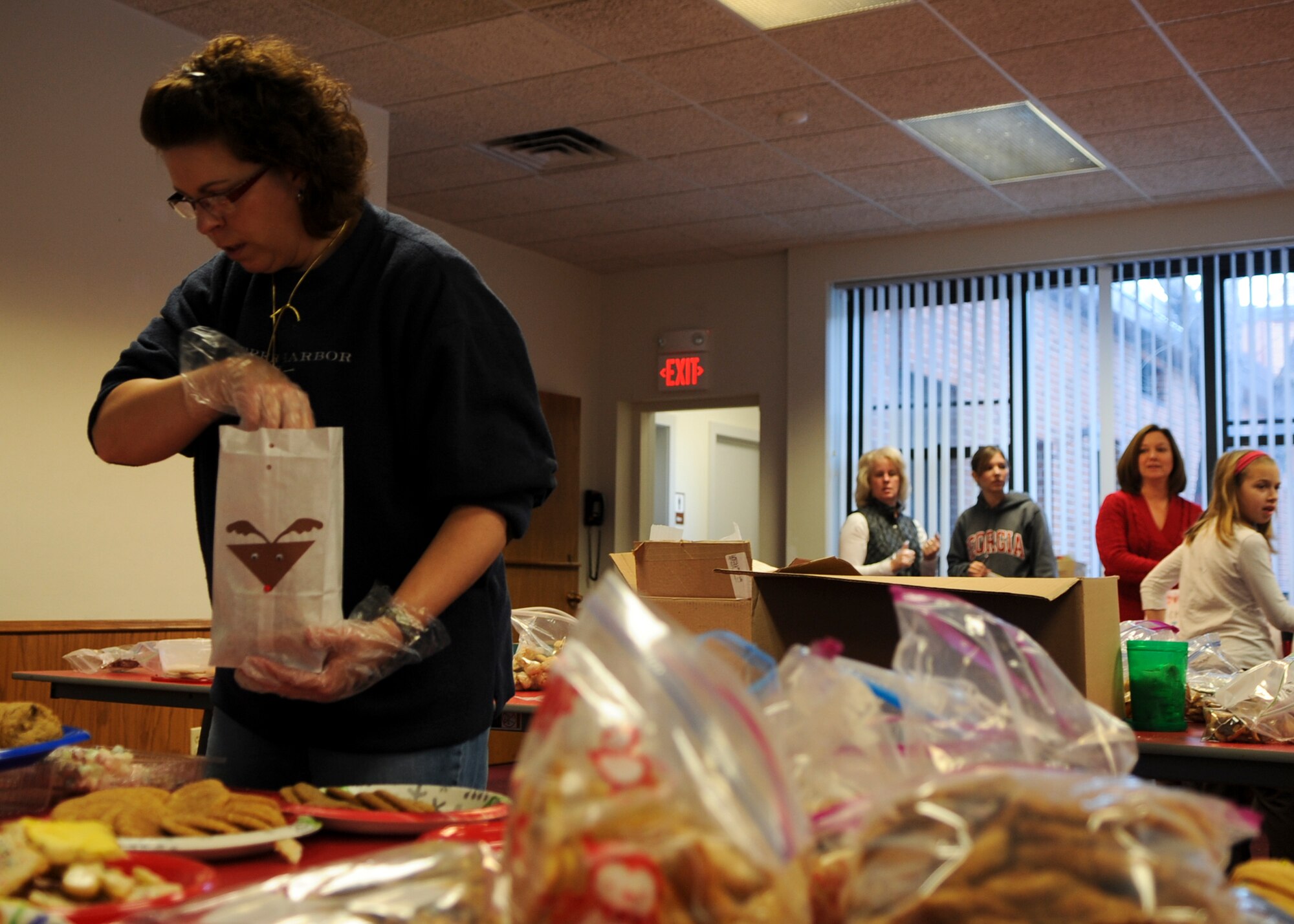 MINOT AIR FORCE BASE, N.D. – Michelle VanBemmelen, spouse of Col. Troy VanBemmelen, 5th Operations Group commander, separate donated Christmas cookies into decorated bags here, Dec 8. Thousands of cookies were collected in three different locations. After cookies are gathered and divided into bags, Minot first sergeants pass the cookies out to the dormitory Airmen. (U.S. Air Force photo/Senior Airman Ashley N. Avecilla)