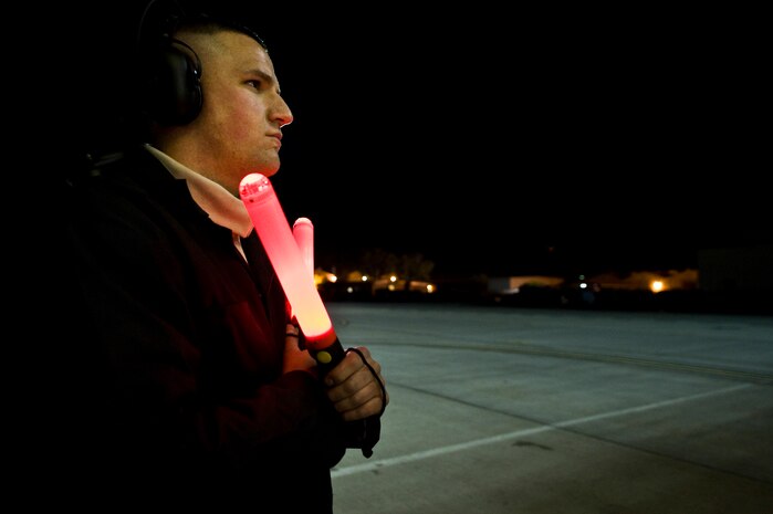 U.S. Air Force Senior Airman Brent Whipple, 757th Aircraft Maintenance Squadron crew chief, waits to marshal an F-15E Strike Eagle during the U.S. Air Force Weapons School mission employment exercise at Nellis Air Force Base, Nev. The two-week-long mission employment phase is the final part of a five-and-a-half-month Weapons School graduate course that showcases the students newly acquired skills to test their ability to plan, execute and lead complex missions. (U.S. Air Force photo by Senior Airman Brett Clashman/Released)
