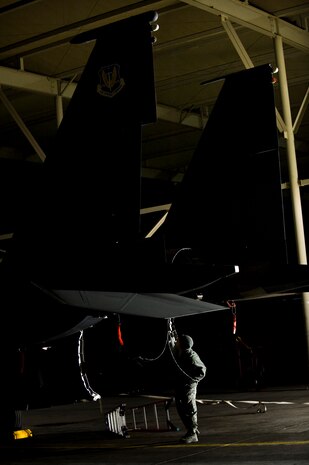 U.S. Air Force Tech. Sgt. Adam Howard, 57th Aircraft Maintenance Squadron quality assurance inspector, inspects inside of an F-15E Strike Eagle during the U.S. Air Force Weapons School mission employment exercise Dec. 6, at Nellis Air Force Base, Nev. The two-week-long mission employment phase is the final part of a five-and-a-half-month Weapons School graduate course that showcases the students newly acquired skills to test their ability to plan, execute and lead complex missions. (U.S. Air Force photo by Senior Airman Brett Clashman/Released)