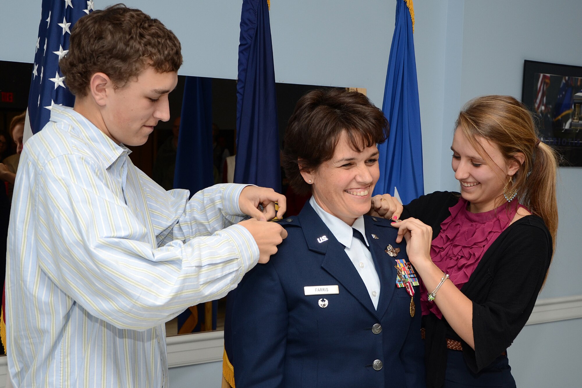 Col. Laurie Farris, Director of State Operations at State Headquarters, is pinned by her two children, son Drew and daughter Taylor, in a promotion ceremony Dec. 3 at Pease Air National Guard Base, N.H.  In her new position, Col. Farris will be responisble for future missions for the N.H. Air National Guard.   (U. S. Air Force photo by Tech. Sgt. Mark Wyatt)