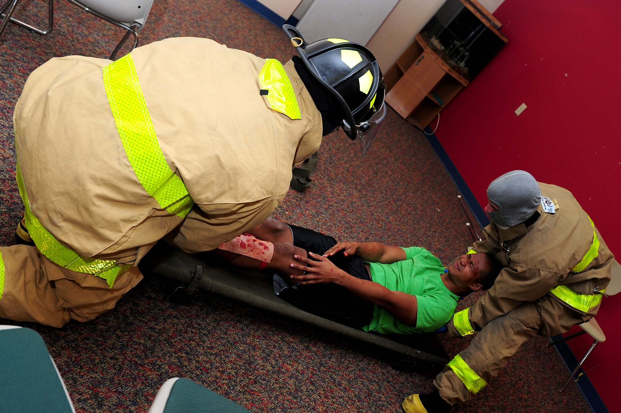 633rd Civil Engineer Squadron firefighters place Airman 1st Class Mark Reposar, 1st Operations Support Squadron air traffic control apprentice, on to a stretcher during an active shooter exercise at Langley Air Force Base, Va., Dec. 8, 2011. Langley AFB conducted the full-scale exercise for assigned units and agencies to exercise plans, checklists, and standard operating procedures. (U.S. Air Force photo by Airman 1st Class Kayla Newman/Released)