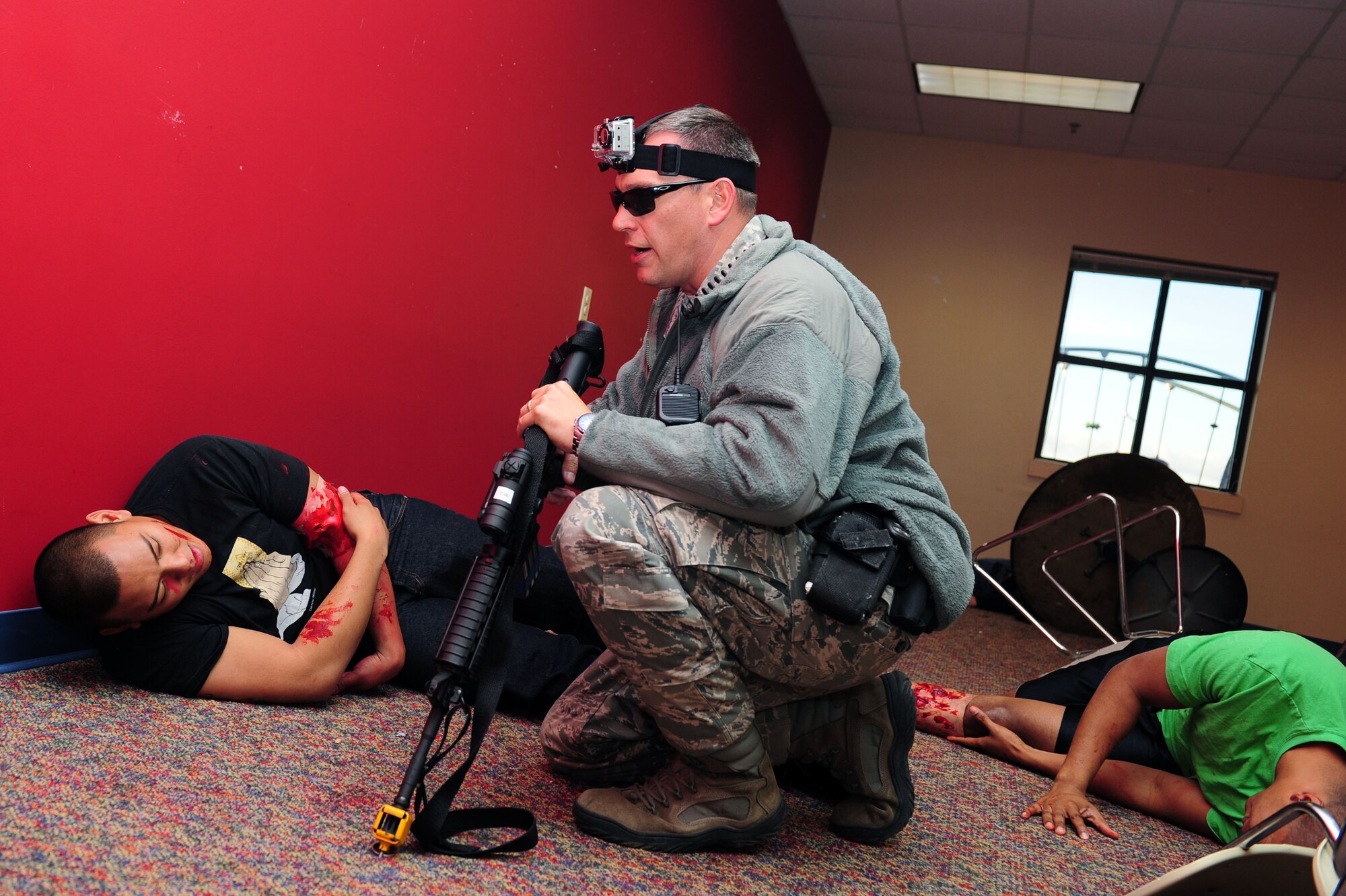 U.S. Air Force Tech. Sgt. James Gardner, 633rd Security Forces Squadron assistant flight chief, checks on injured Airmen 1st Class Matthew Equid, 633rd Logistics Readiness Squadron material management apprentice, and Mark Reposar, 1st Operations Support Squadron air traffic control apprentice, during an active shooter exercise at Langley Air Force Base, Va., Dec. 8, 2011. The exercise allowed Langley AFB to test and evaluate first responders faced with multifaceted events affecting the installation. (U.S. Air Force photo by Airman 1st Class Kayla Newman/Released)