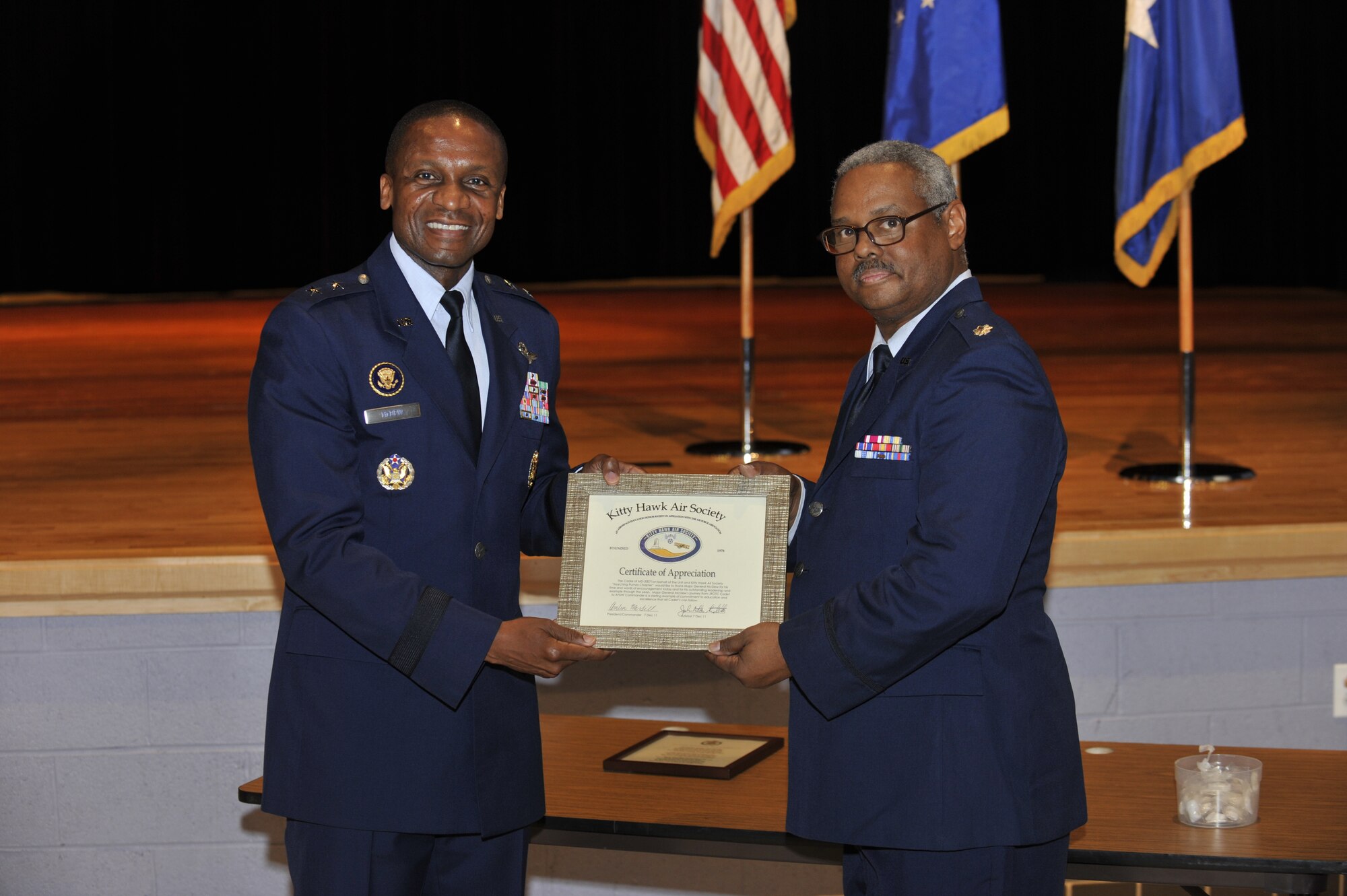 Maj. Gen. Darren W. McDew, Air Force District of Washington commander, receives the Kitty Hawk Air Society certificate of appreciation Dec. 7 during a speaking engagement at the Dr. Henry Wise High School, Upper Marlboro, Md. McDew addressed the school’s Junior Reserve Officer Training Corps cadets with a message that encouraged good stewardship and leadership following the presentation. (U.S. Air Force photo by Tech. Sgt. Raymond MIlls)