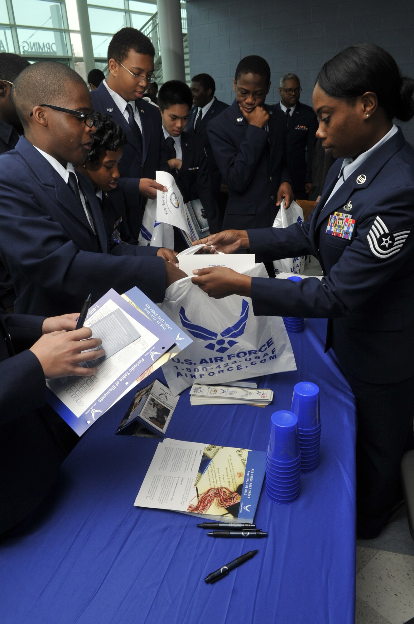 Tech. Sgt. Jeanne Johnson, U.S. Air Force recruiter, hands out information Dec. 7 during a visit to the Dr. Henry Wise High School, Upper Marlboro, Md. Johnson’s visit was in conjunction with a visit from Maj. Gen. Darren W. McDew, Air Force District of Washington commander. McDew and Johnson educated members of the Md. 20071 Air Force Junior Reserve Officer Training Corps about the Air Force mission. (U.S. Air Force photo by Tech. Sgt. Raymond Mills) 