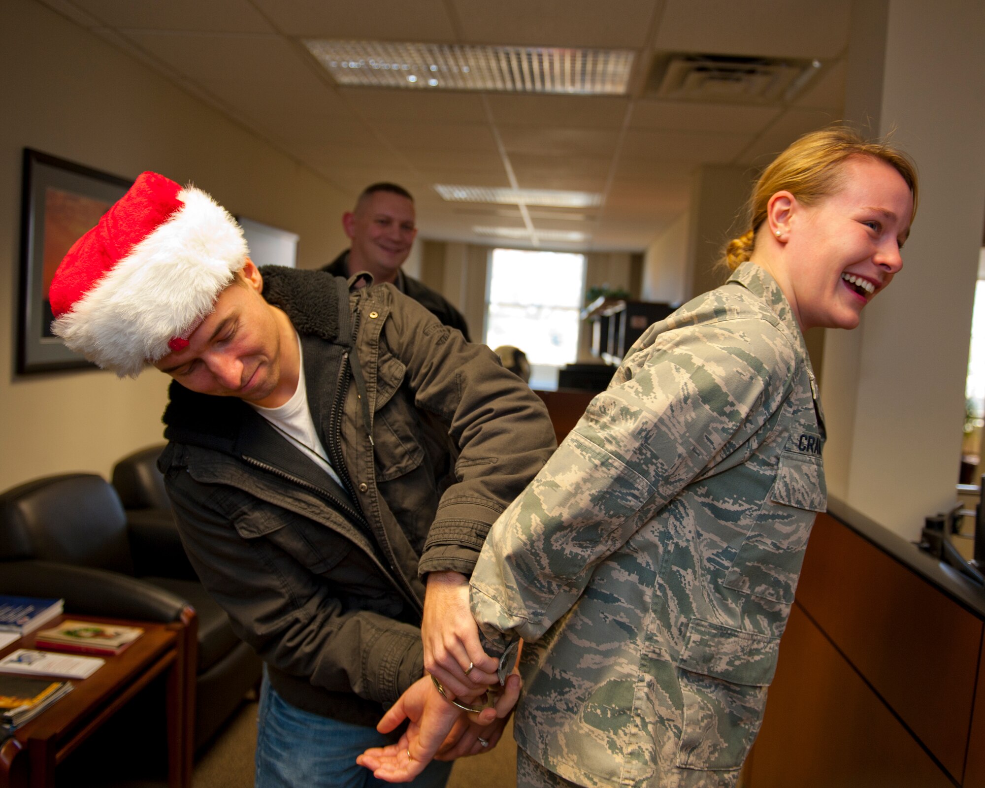 Second Lt. Teresa Crampton, 92nd Mission Support Group executive officer, gets detained by Staff Sgt. Adam Macowicz, 92nd Security Forces Squadron, during the Santa Lock-up Dec. 2. The Santa Lock-up is a yearly fundraiser to help support the Defenders Association and Operation Warm Heart. (U.S. Air Force photo/Staff Sgt. Michael Means)