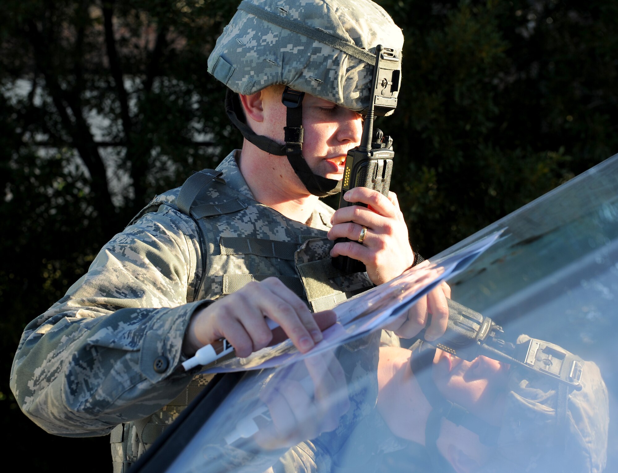 U.S. Air Force Capt. Adam Miller, 633rd Security Forces Squadron operations officer, radios in to the command post during an active shooter exercise at Langley Air Force Base, Va., Dec. 8, 2011. The exercise tested the participants’ ability to address communications, response procedures and command and control between first responders and base command and control. (U.S. Air Force photo by Staff Sgt. Antoinette Gibson/Released)