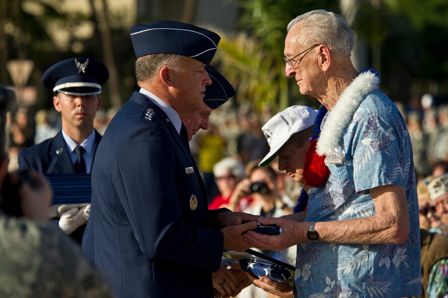 U.S. Air Force Gen. Gary L. North, Pacific Air Forces commander, presents Army Air Corps Veteran Fred Brown a U.S. Flag that was flown in his honor, Dec. 7, 2011, during the Joint Base Pearl Harbor-Hickam remembrance ceremony in recognition of the 70th Anniversary of the 1941 Japanese attacks on Hickam Field. Airmen, their families and veterans gathered at Atterbury Circle, the site of the same flagpole that stood Dec. 7, 1941. The ceremony was held to honor the survivors of the attacks and remember the 238 Army Air Corps Airmen who died defending Hickam Field. (U.S.  Air Force photo by Tech. Sgt. Michael R. Holzworth/Released)