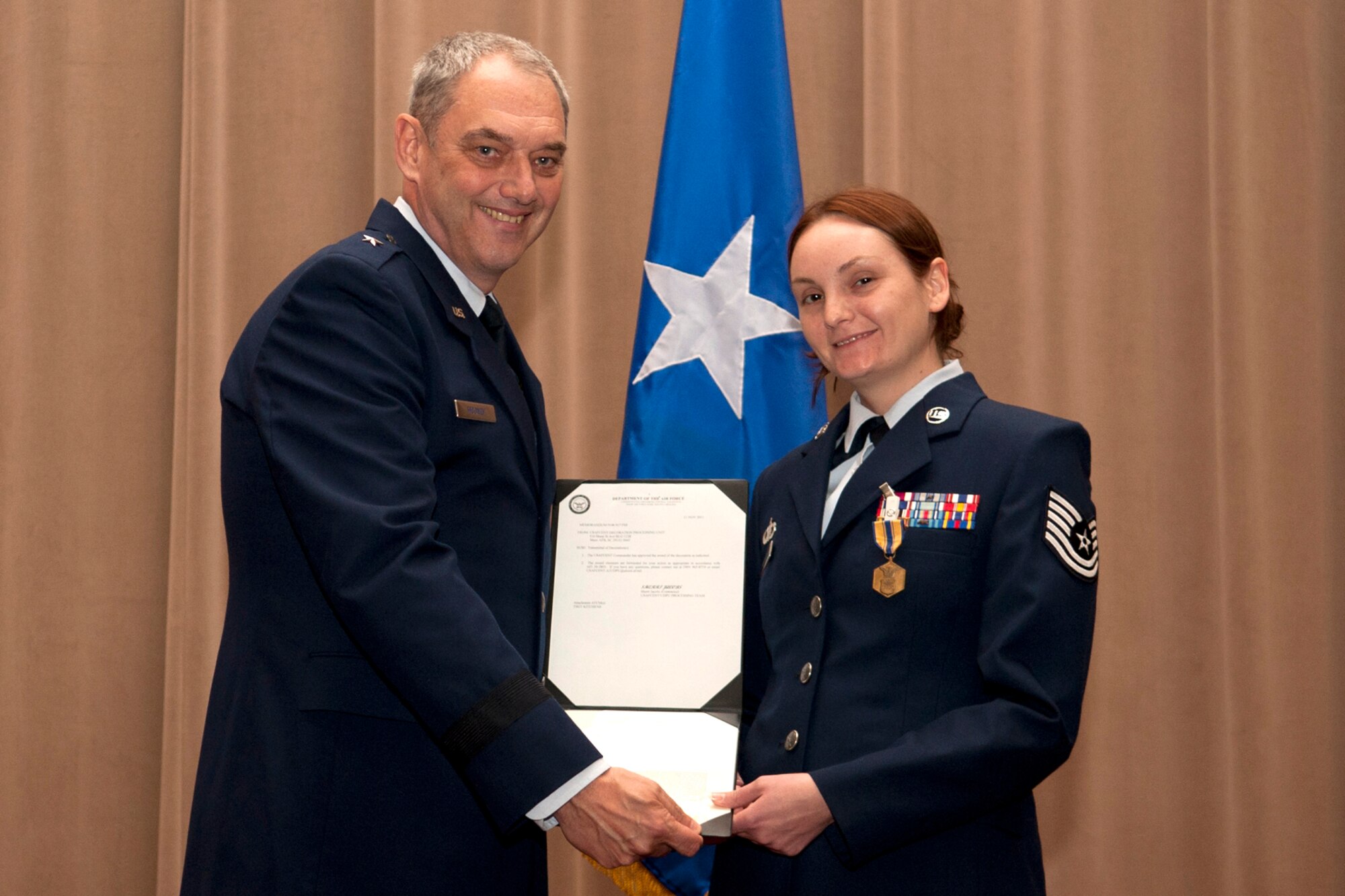 U.S. Air Force Brig. Gen. John Mooney III, 307th Bomb Wing commander, presents the Air Force Commendation Medal to Tech. Sgt. Melissa Kitchens during a commander's call ceremony, Barksdale Air Force Base, La., Nov. 4, 2011. Kitchens was recognized for outstanding achievement as Noncommissioned Officer in Charge of the 451st Air Expeditionary Wing Command Post, Kandahar Airfield, Afghanistan, from Jan. 26, 2011 to July 29, 2011. (U.S. Air Force photo by Master Sgt. Greg Steele/Released)