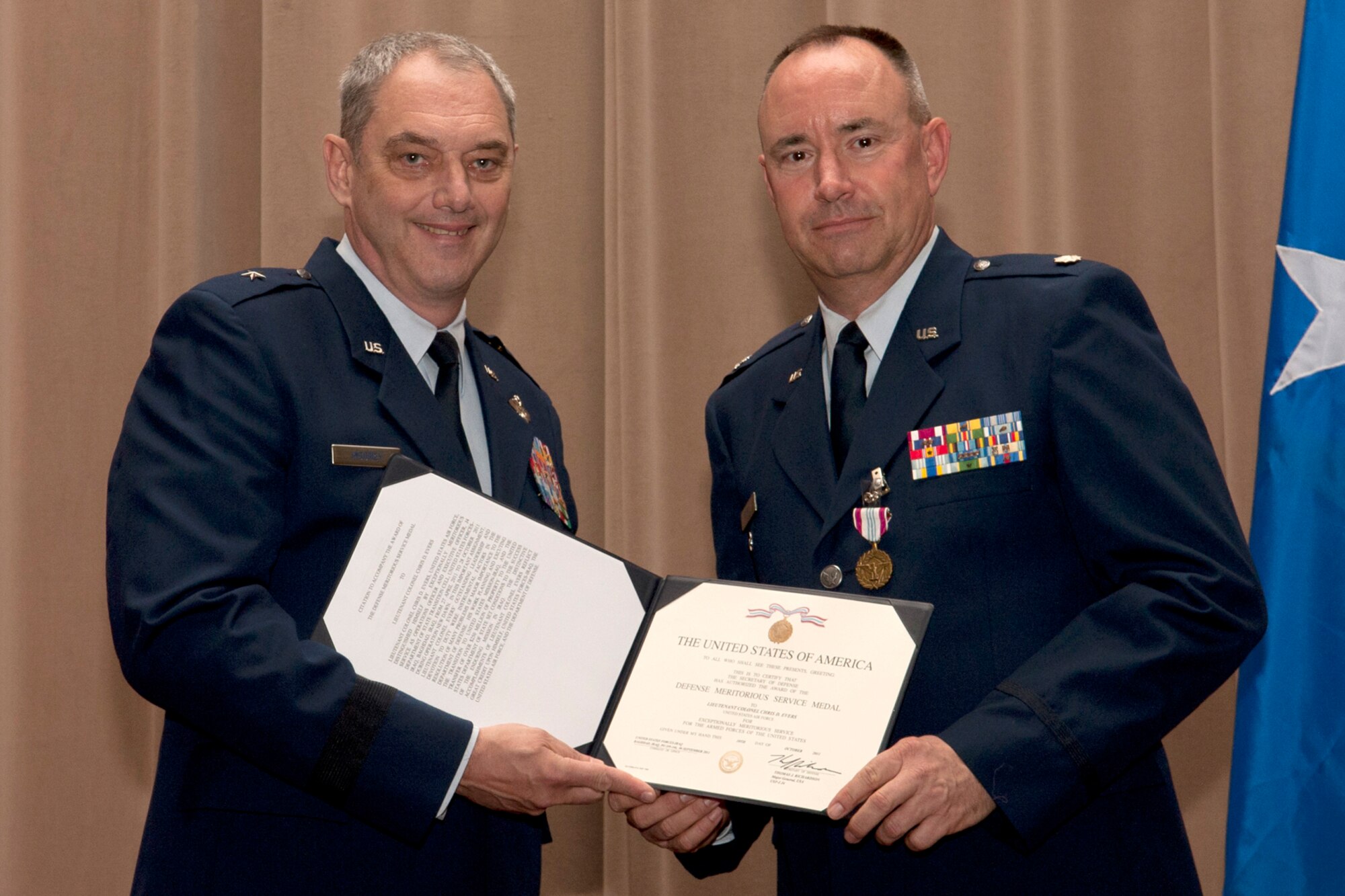 U.S. Air Force Brig. Gen. John Mooney III, 307th Bomb Wing commander, presents the Defense Meritorious Service Medal to Lt. Col. Chris Evers during a commander's call ceremony, Barksdale Air Force Base, La., Nov. 4, 2011. Evers was recognized for meritorious outstanding service while assigned to the J4 Department of State Transition Cell, United States Forces-Iraq, Baghdad, Iraq, from April 27, 2011 to Oct. 28, 2011. (U.S. Air Force photo by Master Sgt. Greg Steele/Released)