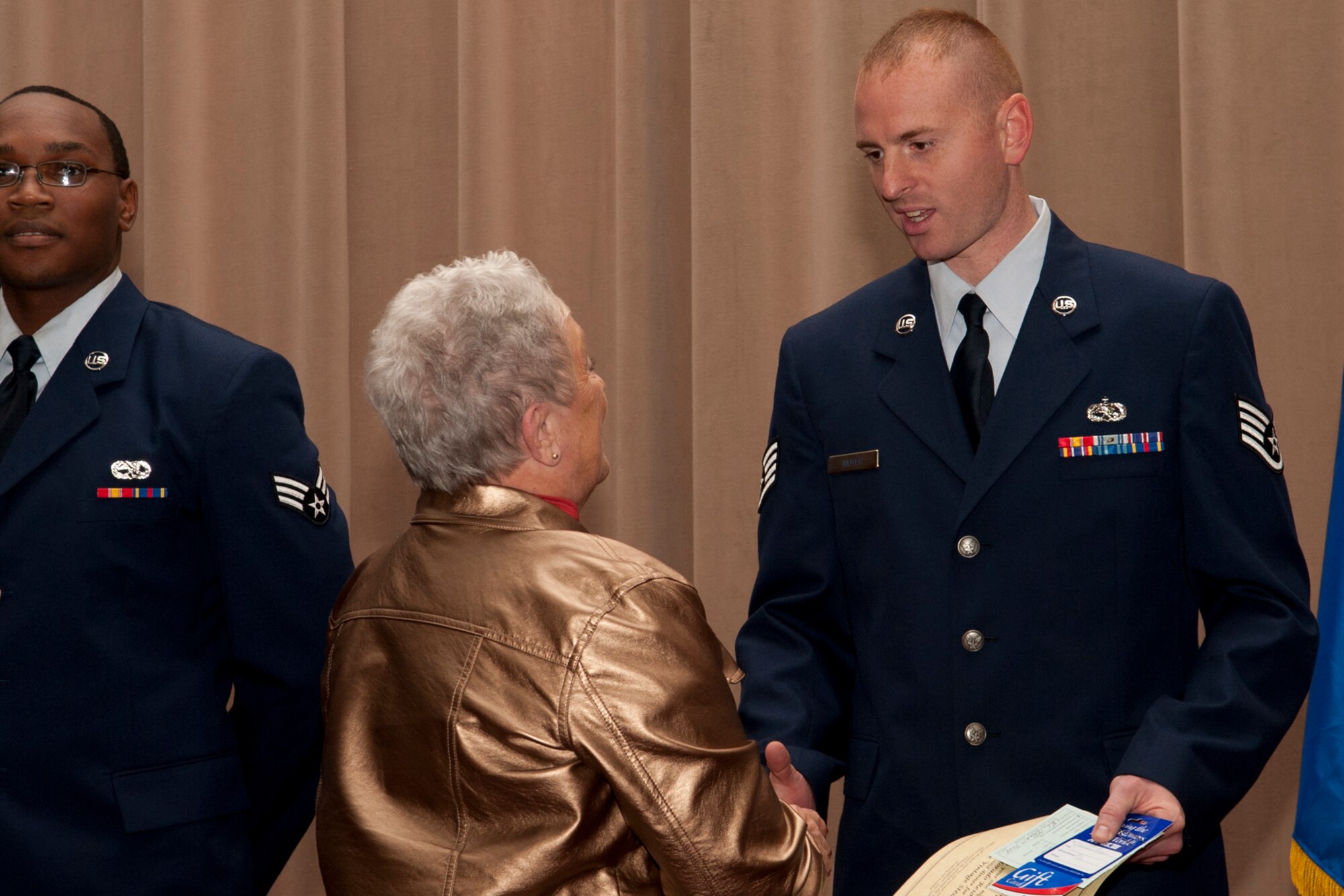 Mrs. Helen Black, from the El Dorado Casino and Resort, presents Staff Sgt. Russell Moyer with gift certificates during an awards ceremony, Barksdale Air Force Base, La., Dec. 4, 2011. Moyer, assigned to the 307th Maintenance Squadron, was recognized as the Noncommissioned Officer of the Quarter for the period covering July to September 2011. (U.S. Air Force photo by Master Sgt. Greg Steele/Released)