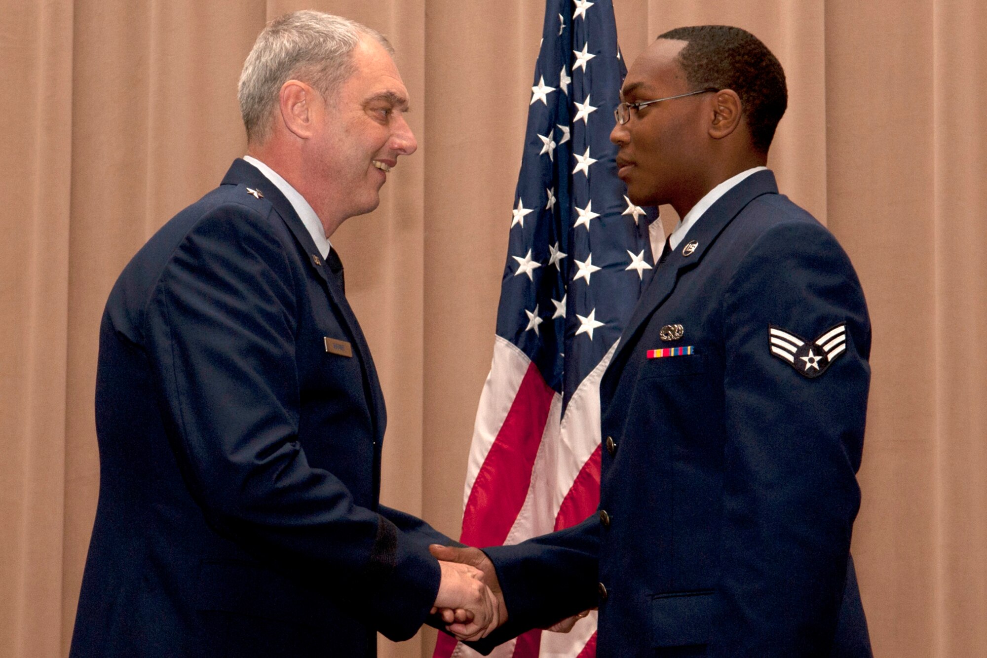 U.S. Air Force Brig. Gen. John Mooney III, 307th Bomb Wing commander, congratulates Senior Airman Undre Hooper during an awards ceremony, Barksdale Air Force Base, La., Dec. 4, 2011. Hooper, assigned to the 307th Maintenance Squadron, was recognized as the Airman of the Quarter for the period covering July to September 2011. (U.S. Air Force photo by Master Sgt. Greg Steele/Released)