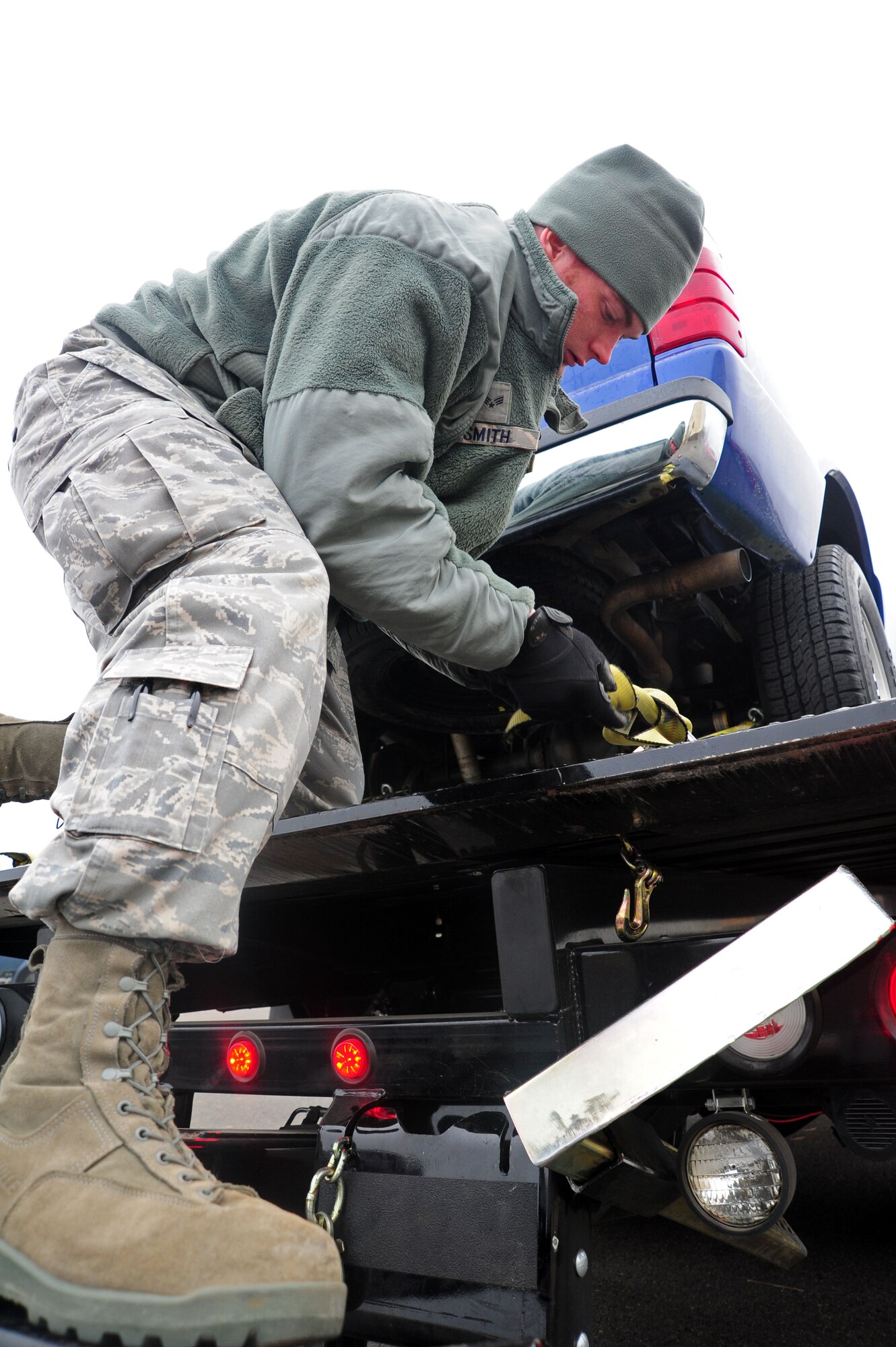 Airman 1st Class Austin Williams, 92nd Logistics Readiness Squadron, uses a roll-back wrecker to pull a government vehicle onto the back end of a truck Dec. 1. One of the primary duties for the members of Vehicle Operations is to manage the transportation and issue of government vehicles. (U.S. Air Force photo/Airman 1st Class Taylor Curry)