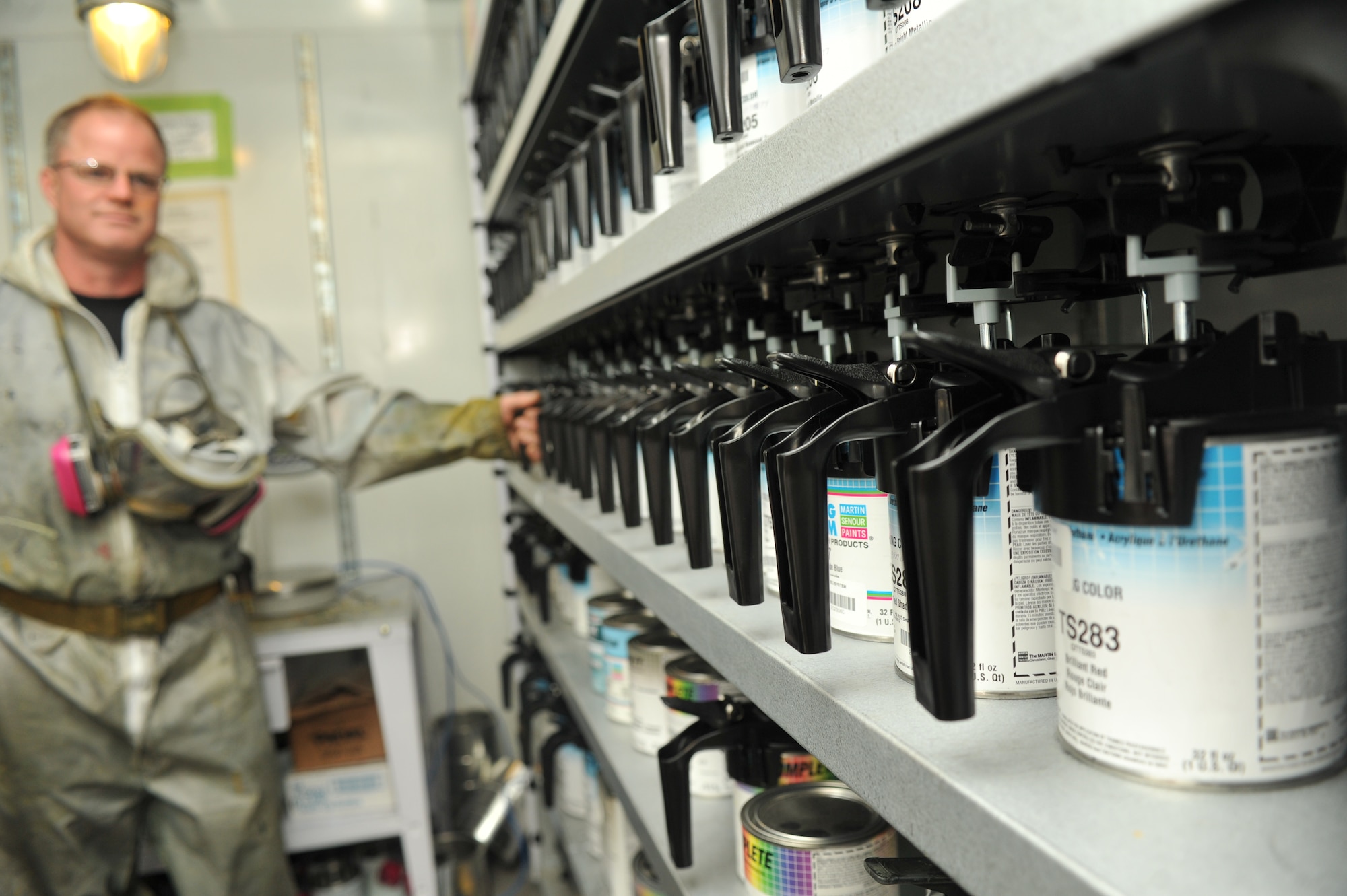 Mark Kannegard, Allied Trades technician, grabs paint from the paint mixer in the vehicle maintenance painting area Dec. 2. In order to get the color they need, they go through a process of mixing by the hundredth of a gram. (U.S. Air Force photo/Airman 1st Class Tyirez Frost)