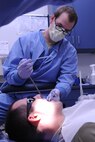 Airman 1st Class Kristopher Little uses an air and water syringe to rinse a patient’s mouth during a refill cavity procedure on Seymour Johnson Air Force Base, N.C., Dec. 7, 2011.  Little is a 4th Aerospace Medicine Squadron dental technician who prepares the room and equipment before the patient and dentist arrive to ensure everything is ready. Little is from Charleston, S.C. (U.S. Air Force photo by Senior Airman Whitney Stanfield) 