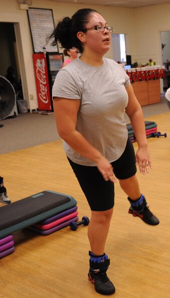 Christina Santana performs leg lifts with ankle weights during an hour long target fit class at BellaMorphosis on Seymour Johnson Air Force Base, N.C., Dec. 7, 2011. Ankle weights are used to work the muscles harder and add resistance during exercise. Santana is a military spouse from Staten Island, N.Y. (U.S. Air Force photo by Senior Airman Whitney Stanfield)