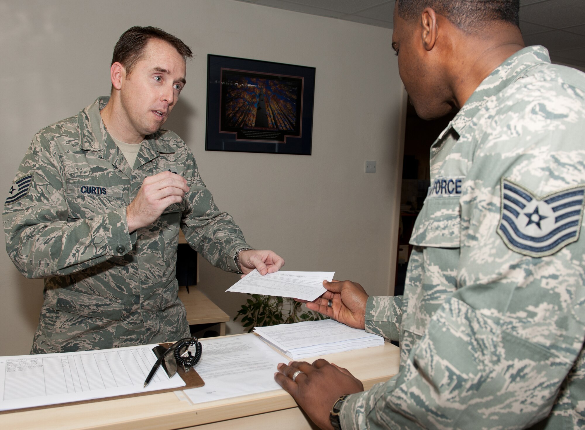 RAF ALCONBURY, United Kingdom -Tech. Sgt. Patrick Curtis, 501st Combat Support Wing Finance Office, helps a customer with a finance question. Curtis was recently recognized as the November Innovator of the Month. (U.S. Air Force photo by Senior Airman Joel Mease)